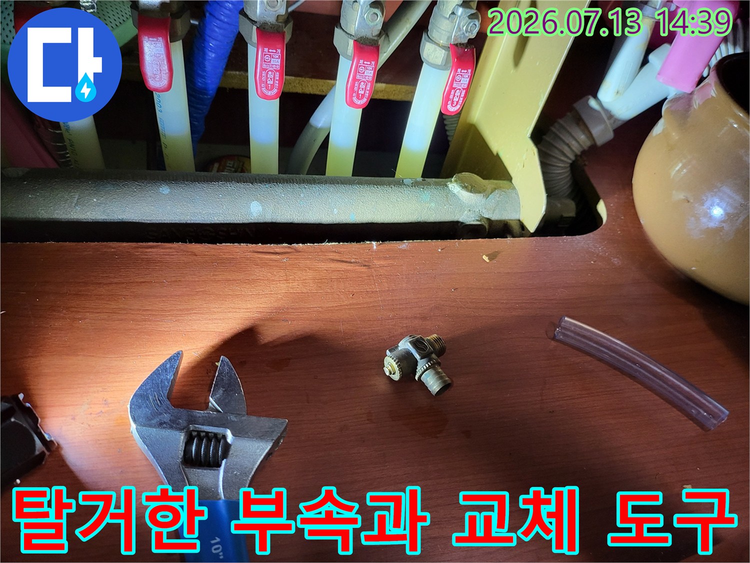 분배기-배관-앞에-나열된-금속-커넥터와-공구-및-투명한-고무-호스
