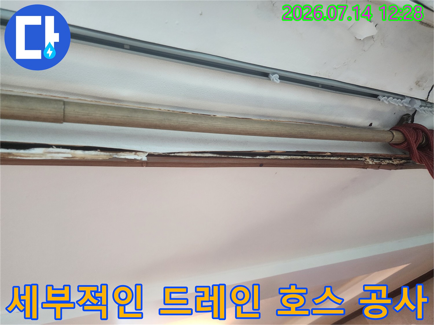 어두운 천장 내부 공간에 설치된 배관과 빨간색 소매 형태의 연결부