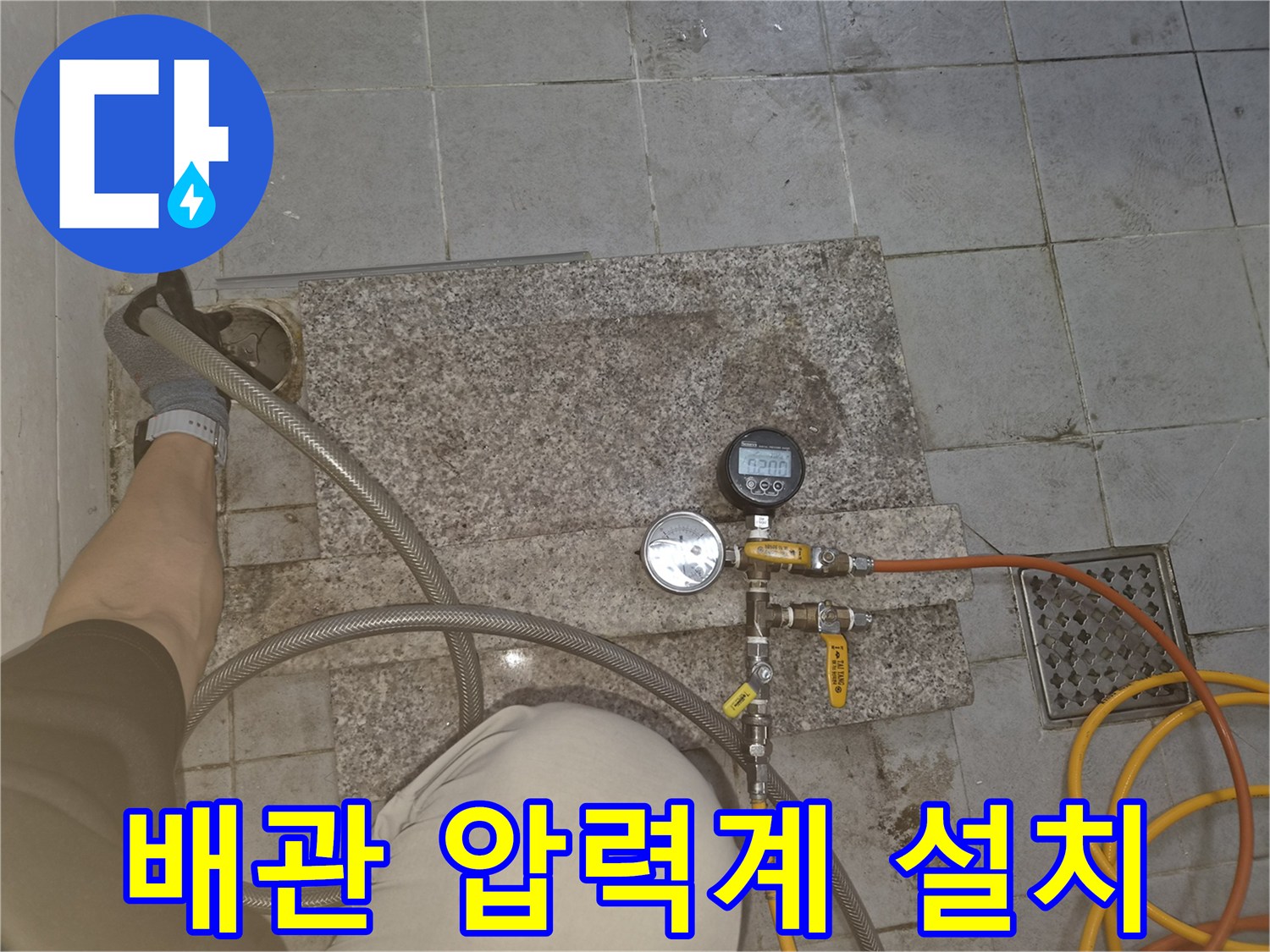 배관 연결 부위에 장착된 압력 게이지와 유선 호스입니다.