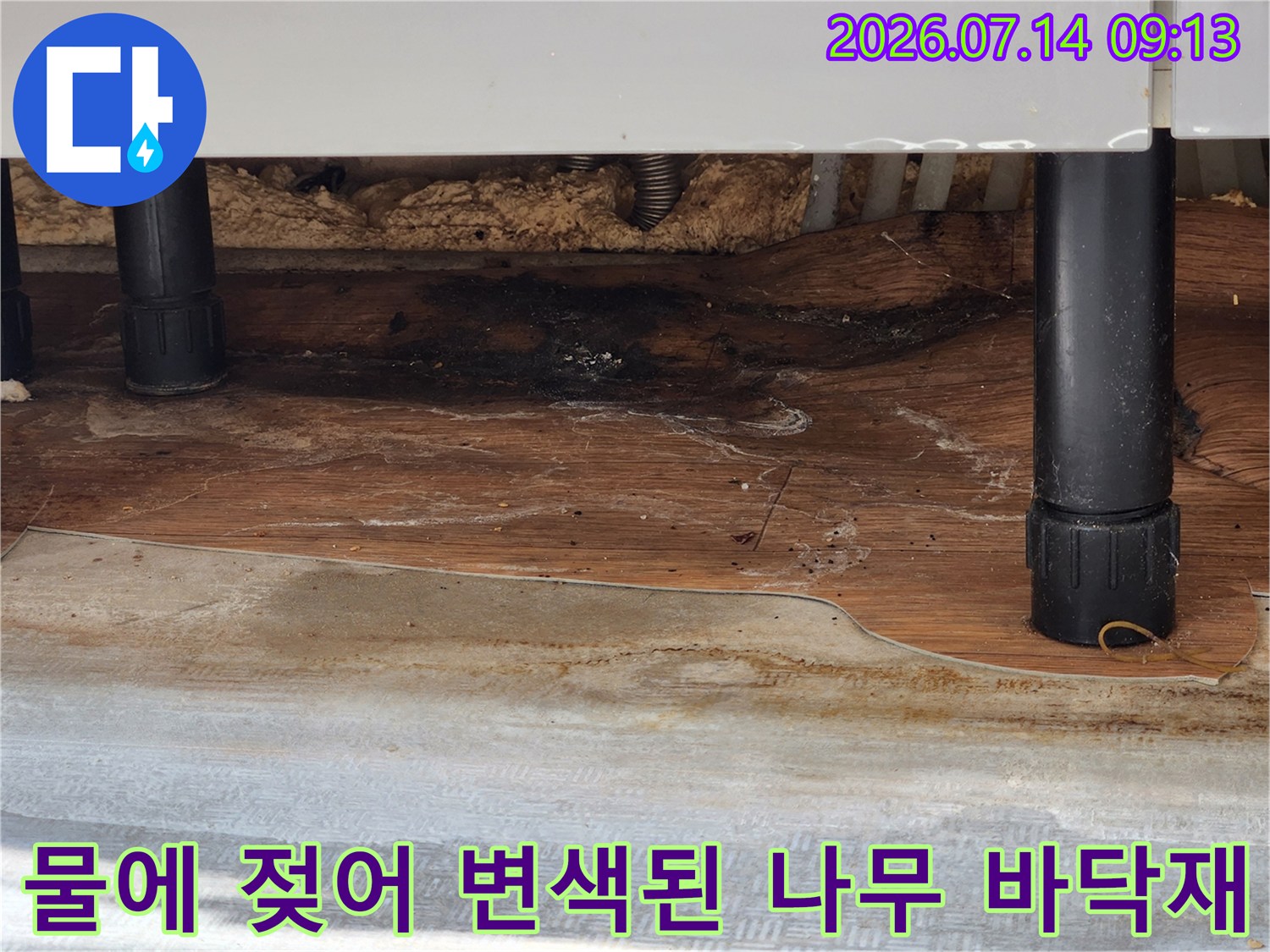 싱크대 하부의 나무 마감재가 습기로 인해 어두운 색으로 변한-장면