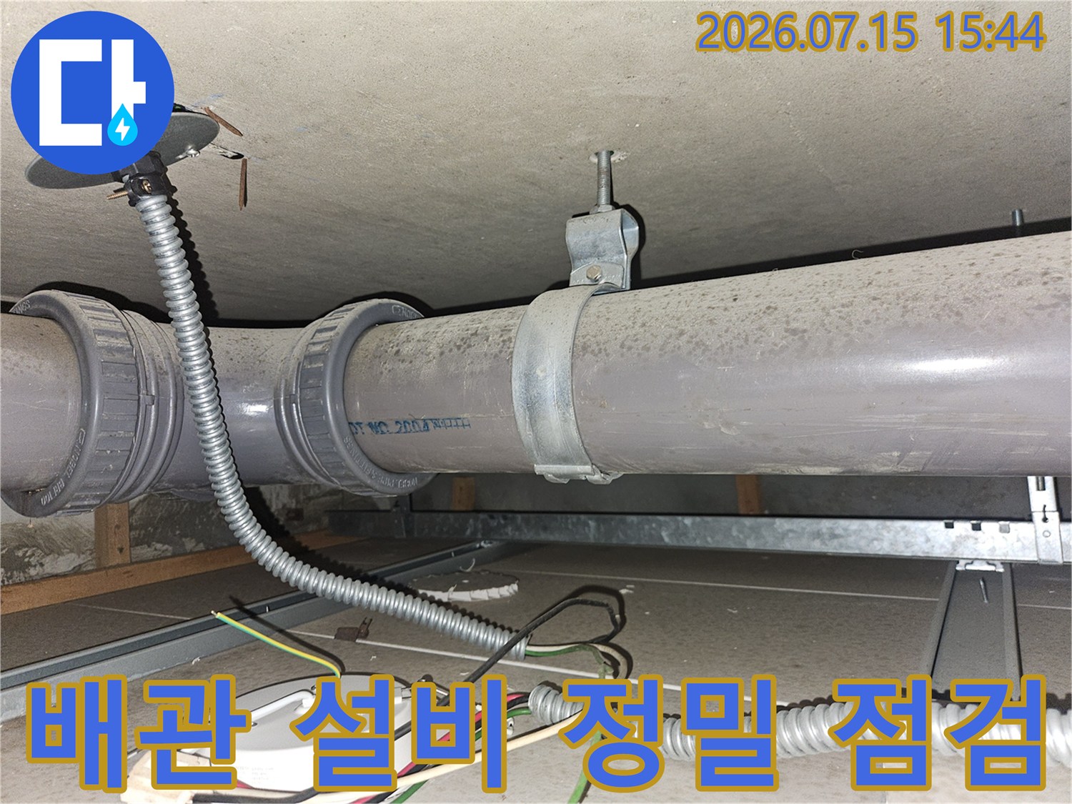 금속 파이프와 보호용 호스가 혼재된 공간에서의 배관 시스템 보강 점검.