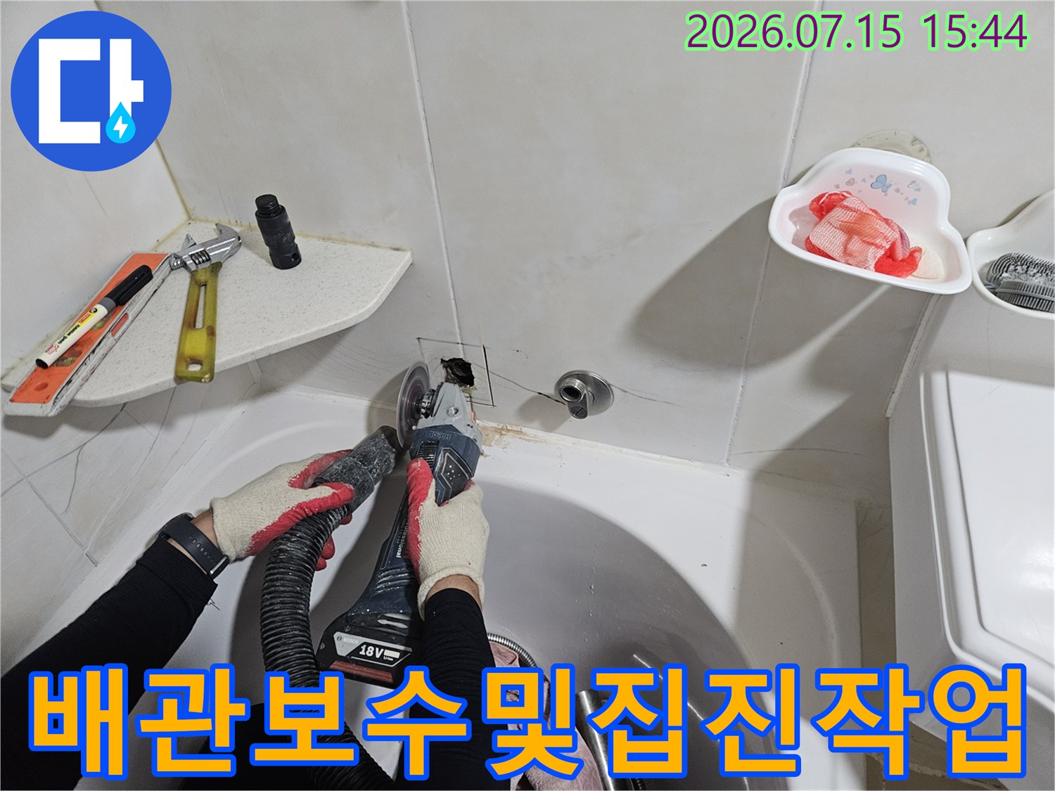 세면대 밑 배관의 누수 지점을 청음 장비로 확인하고 집진기를 사용하여 정밀하게 수리하는 모습입니다.