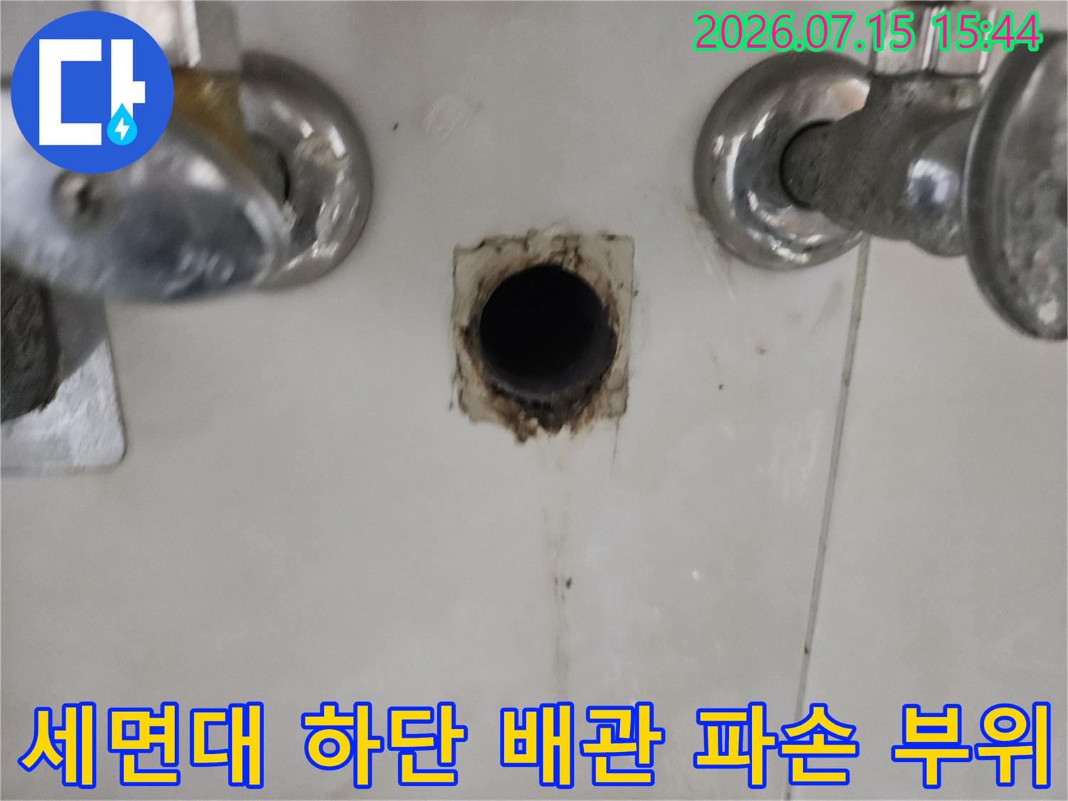 세면대 아래 노출된 배관의 균열 및 누수 지점 촬영 사진