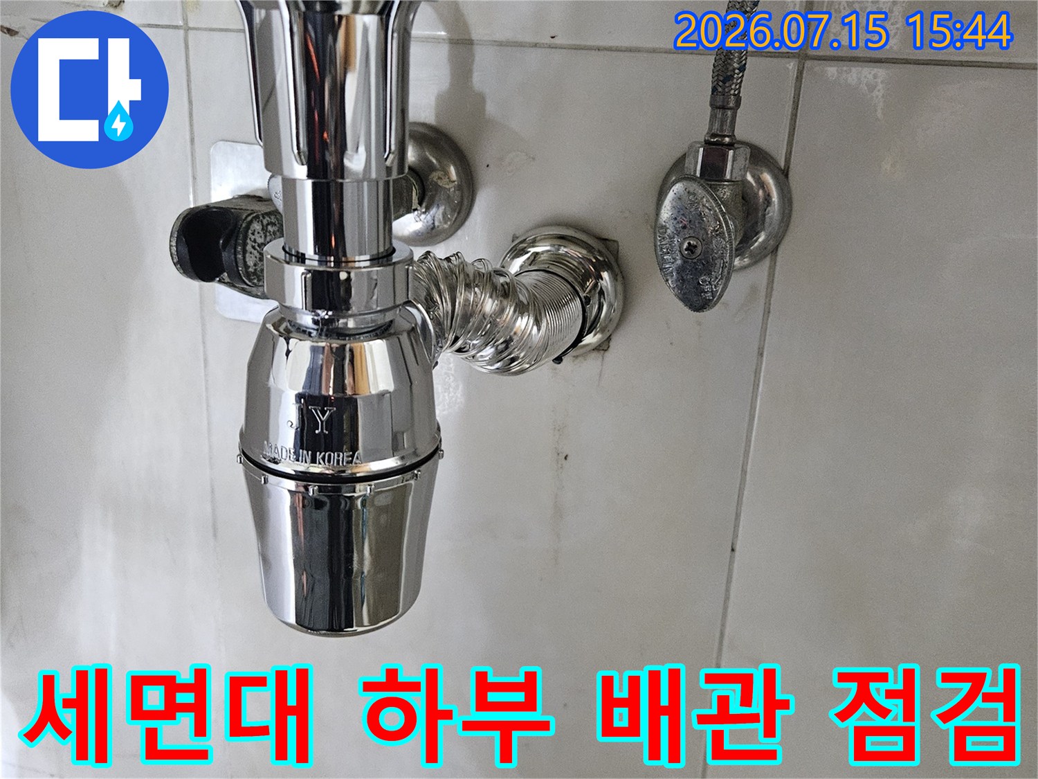 세면대 아래 노출된 크롬 도금 배관과 연결 부위의 상세 모습