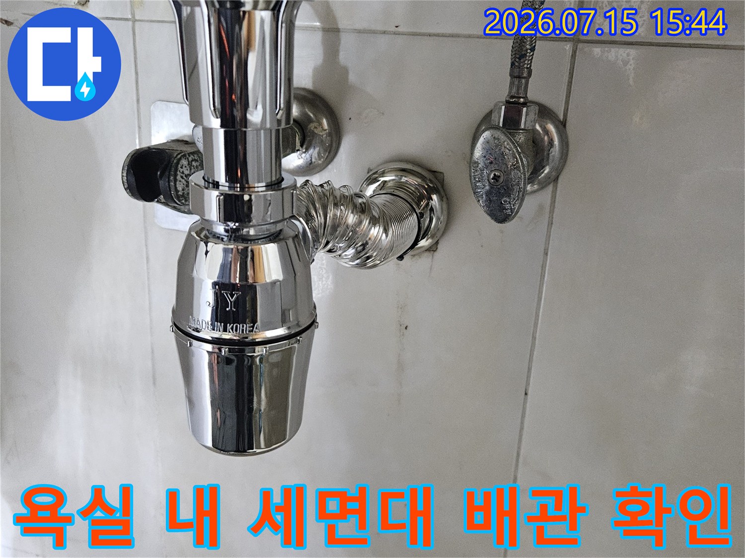 세면대 하부에 노출된 배관 시스템과 연결 부위의 근접 촬영본입니다.