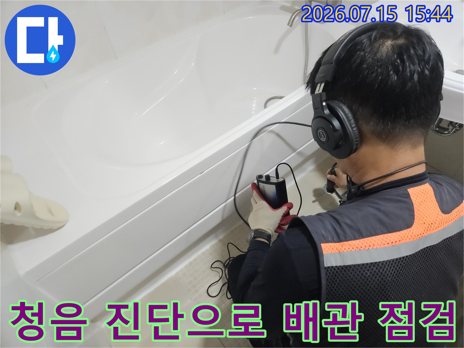 욕실 내 세면대 하부 공간에서 청음 장비를 사용하여 정밀하게 누수 위치를 찾아내는 장면