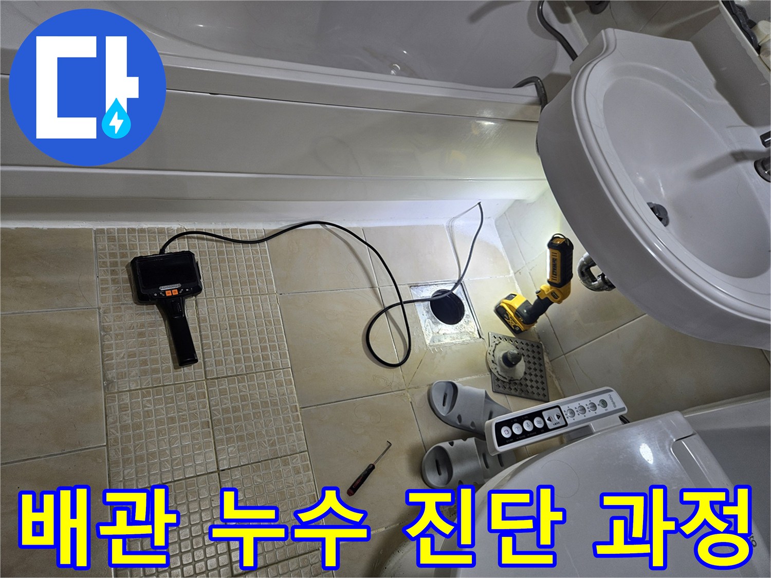 욕실 바닥에 설치된 압력계와 작업용 전동 공구