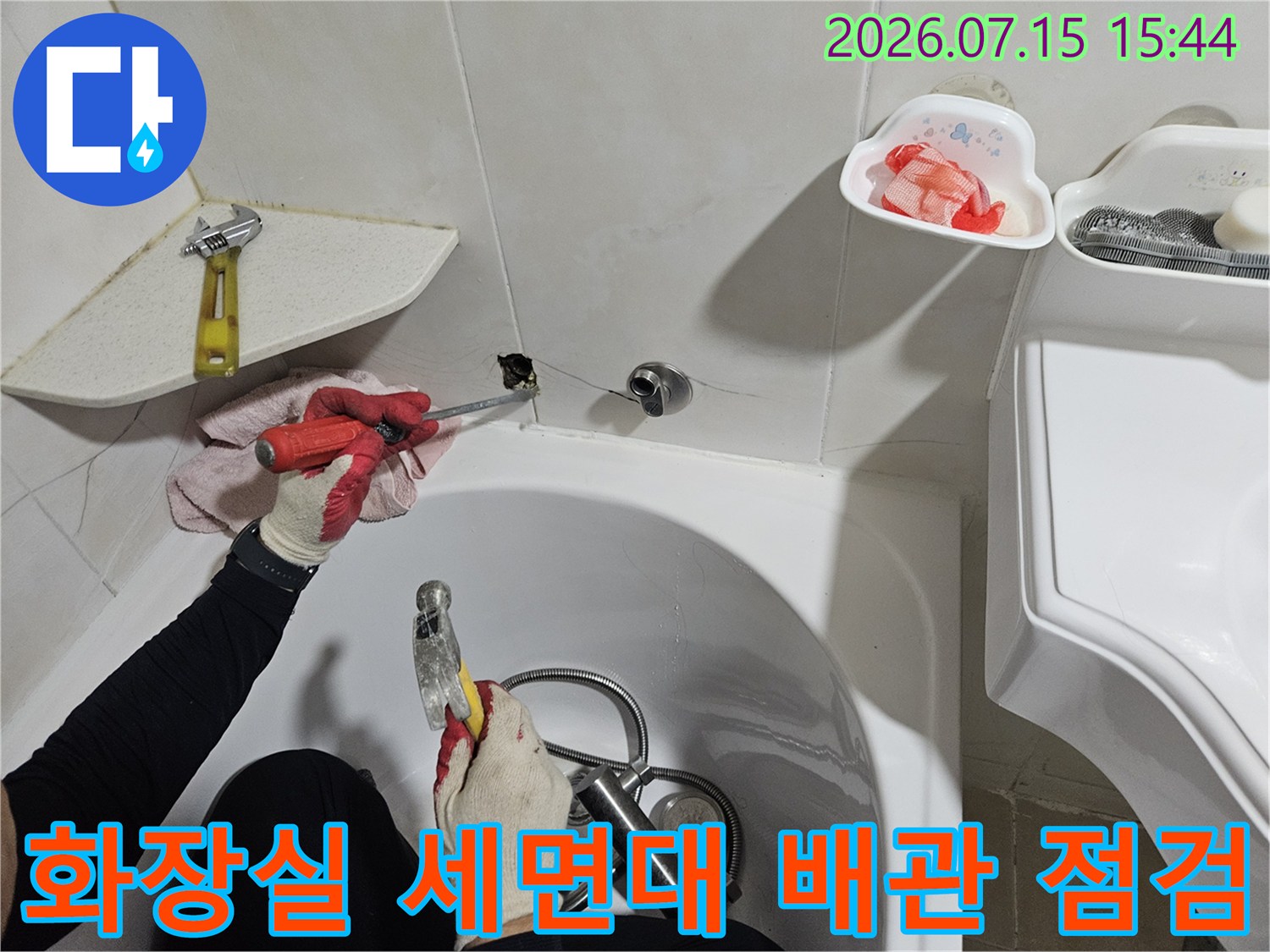 작업자가 세면대 아래 노출된 배관의 누수 여부를 꼼꼼하게 확인하고 있는 장면