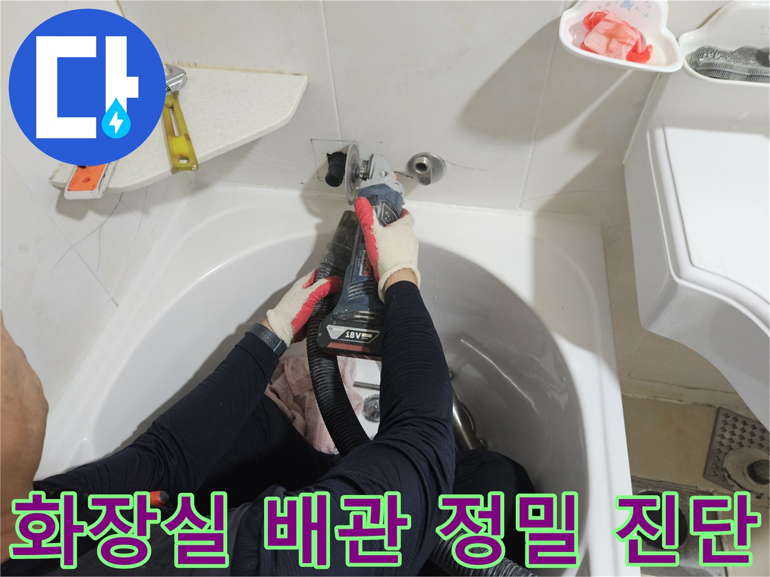 작업자가 화장실 벽면 수전 아래쪽 배관의 누수 여부를 확인하기 위해 점검 중입니다.