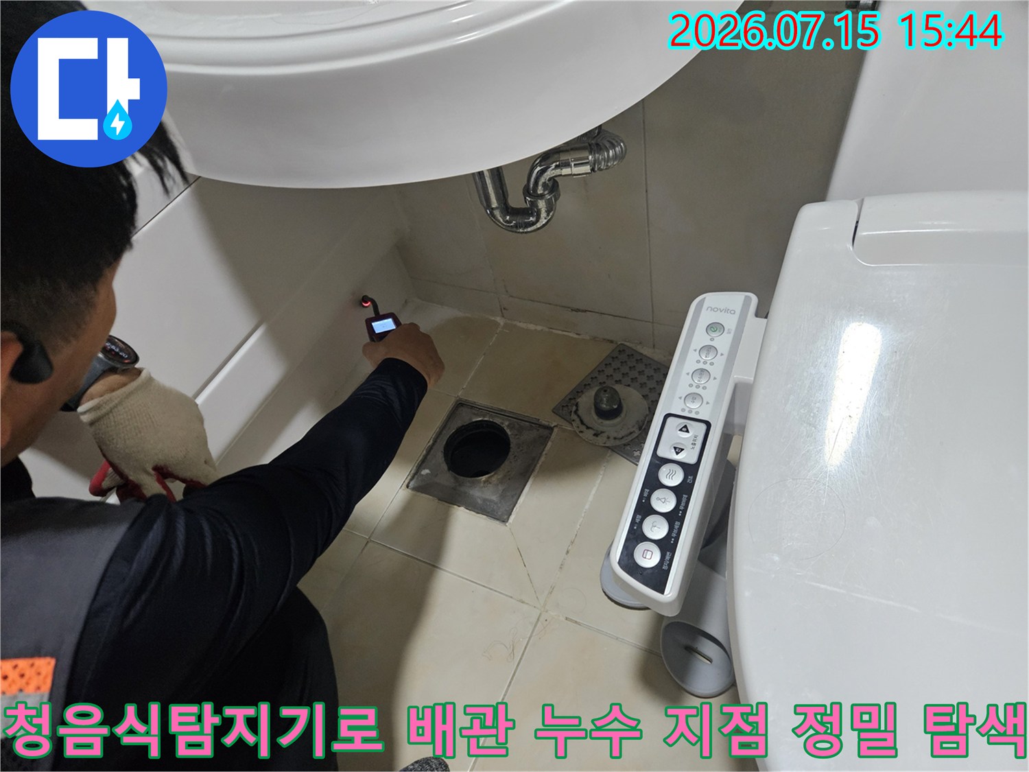 전문가용 청음식 탐지기를 사용하여 세면대 하부 배관의 누수 위치를 파악하는 장면