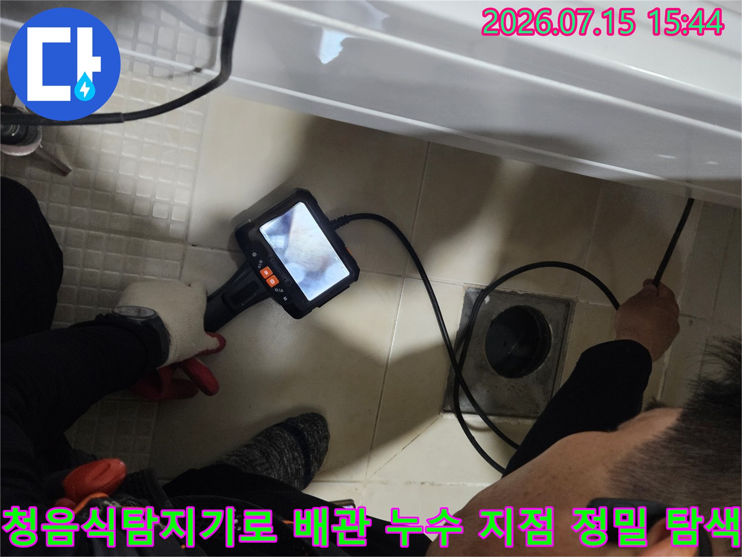 전문가용 청음식 탐지기를 사용하여 욕실 세면대 아래 배관의 누수 위치를 정밀하게 추적하는 모습