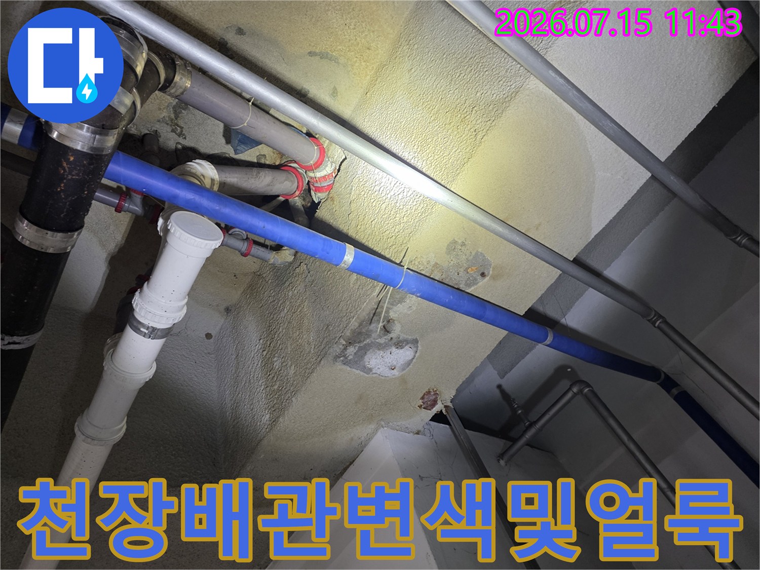 콘크리트-표면에-노란색으로-번진-누수-흔적과-설치된-배관들