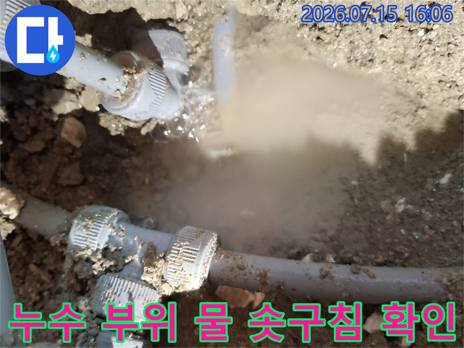 회색의 수도 배관 연결 커넥터 부분에서 누수가 발생해 하얀 물줄기가 올라오는 장면