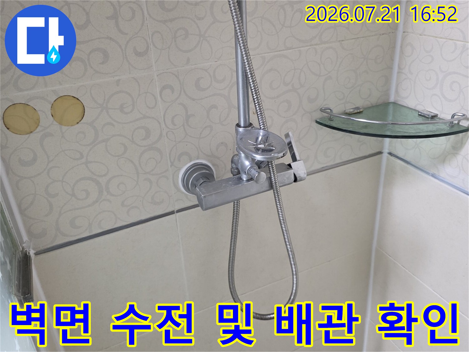 욕실 벽면에 설치된 금속 재질의 샤워기 수전과 고정용 부품들