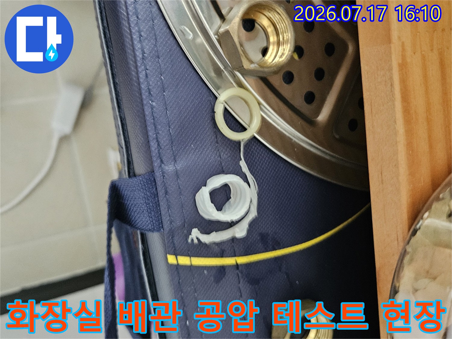 노출된 배관 부위에 압력계와 커플링을 연결하여 공압 테스트를 진행하는 장면
