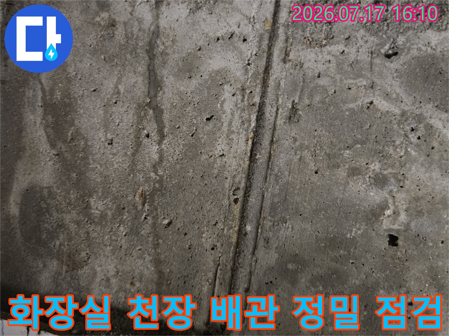 화장실 콘크리트 천장면의 배관 연결 부위와 균열 상태를 조사하는 모습