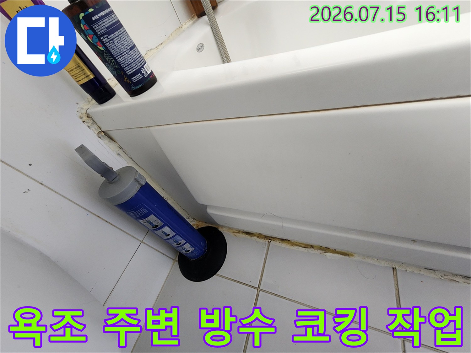 욕조 하단 마감재가 손상된 부위에 실리콘 건과 도구들을 배치한 현장 사진