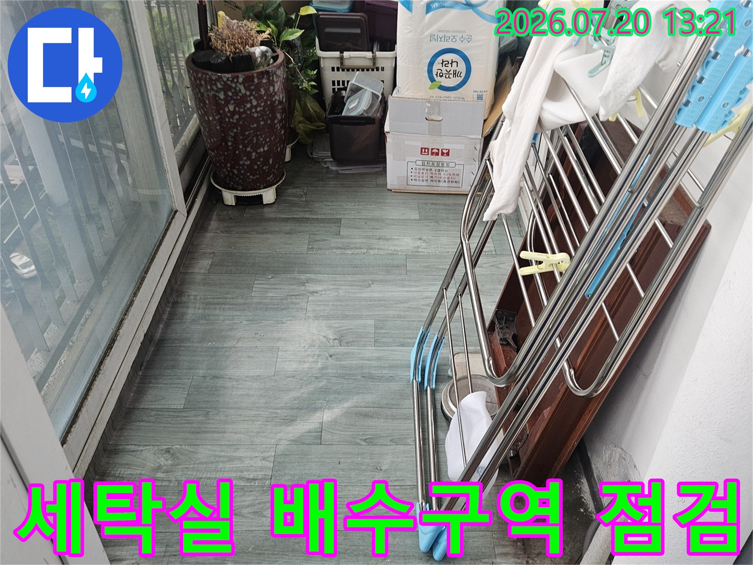 세탁실에 위치한 하얀색 배수관과 주변 환경을 정밀하게 점검하는 현장 사진