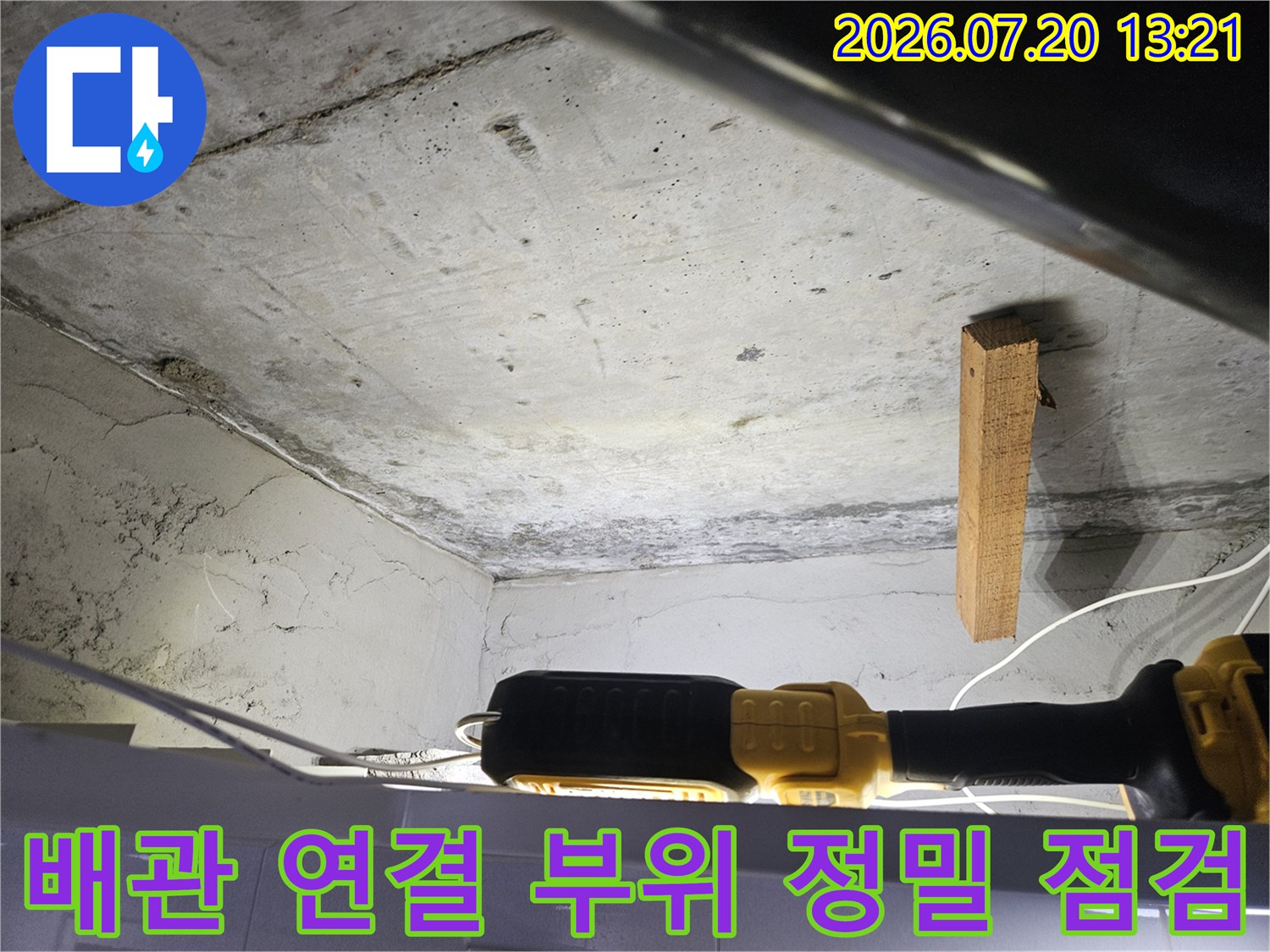 천장 내부 배관과 연결된 부위를 집중적으로 관찰하며 누수를 확인하는 모습