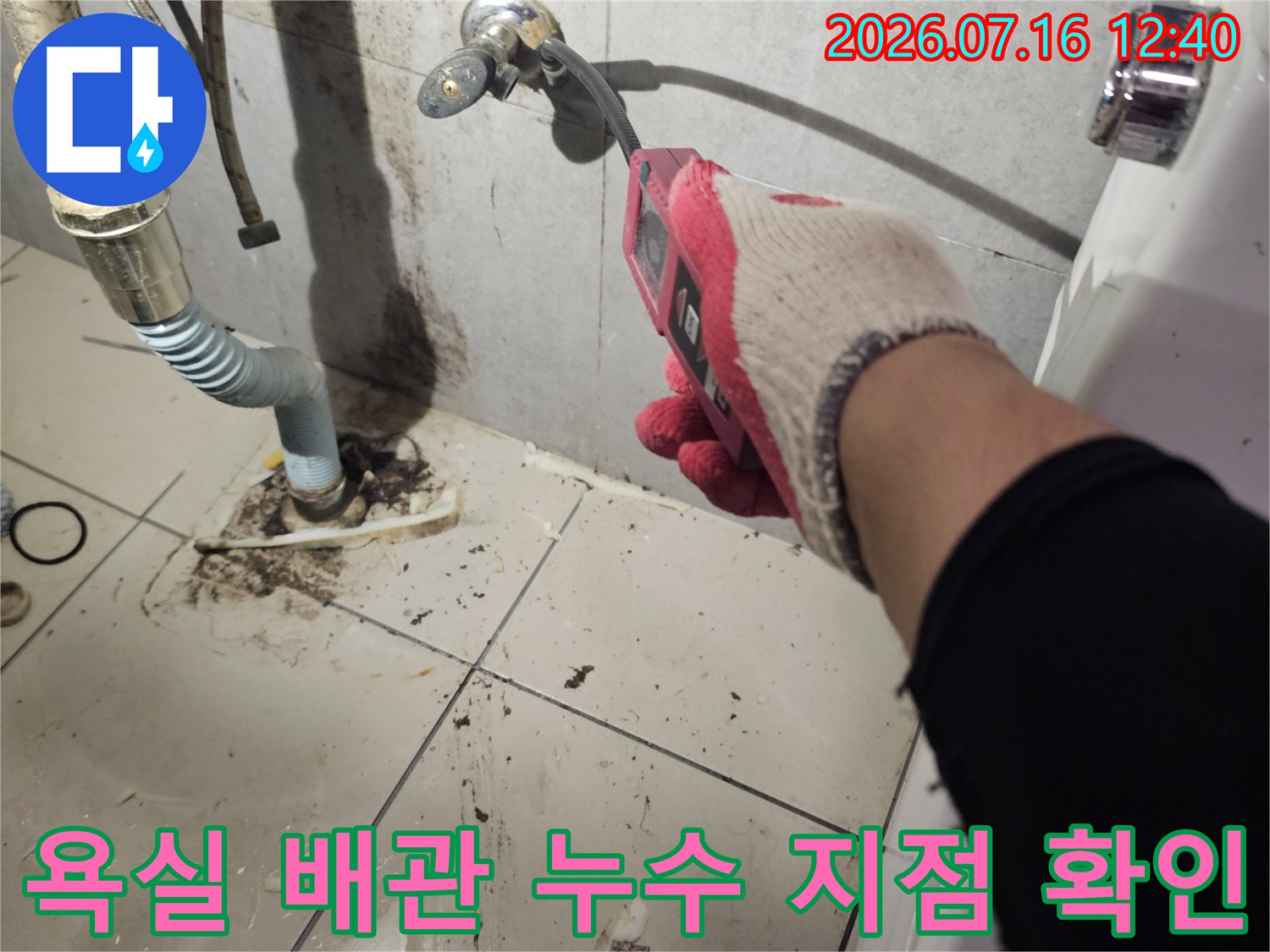 파헤친 타일 사이로 노출된 파손 배관을 수리하는 모습