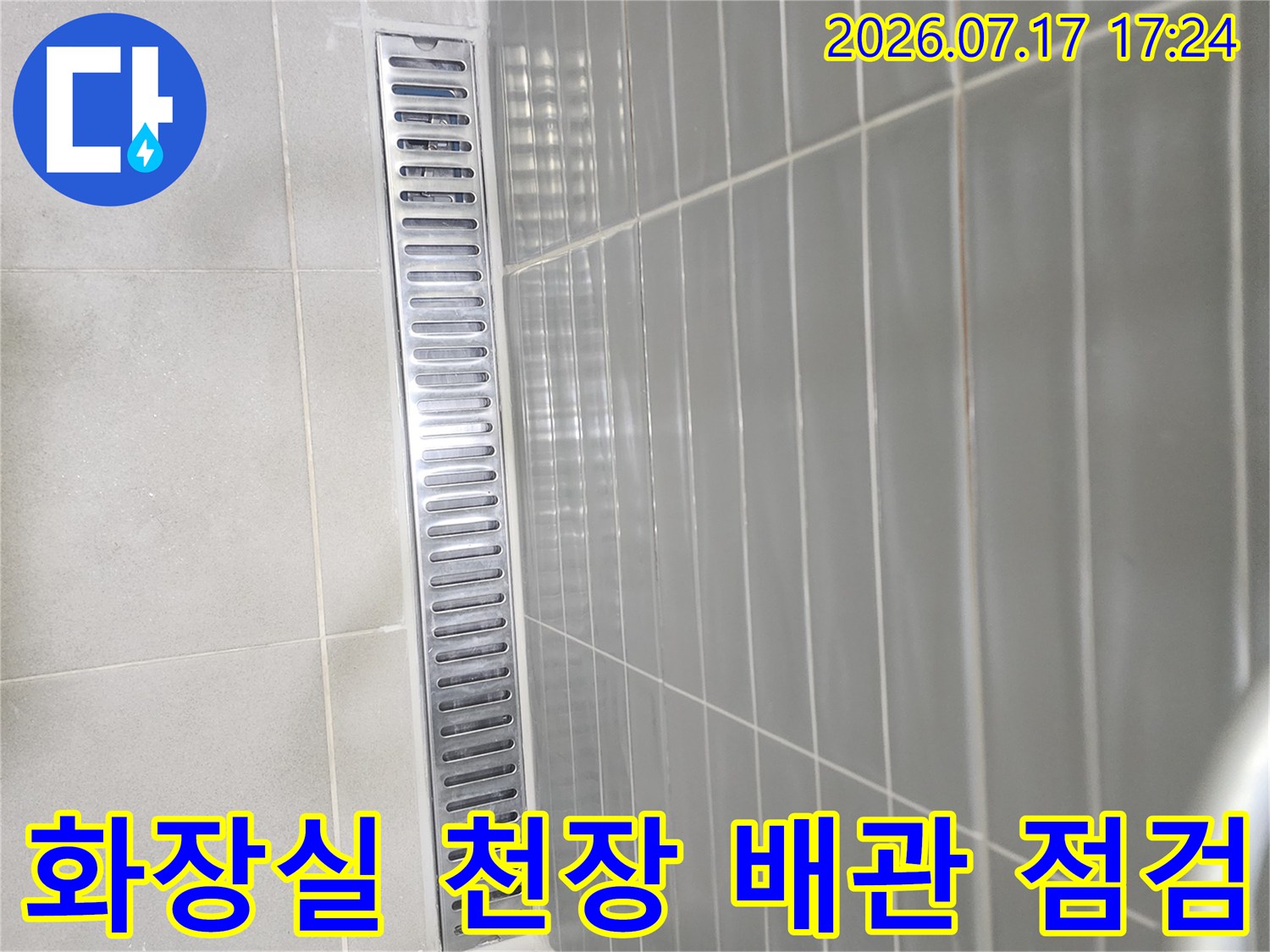 화장실 천장 안쪽의 금속제 배관과 환기구 구조물이 노출된 모습