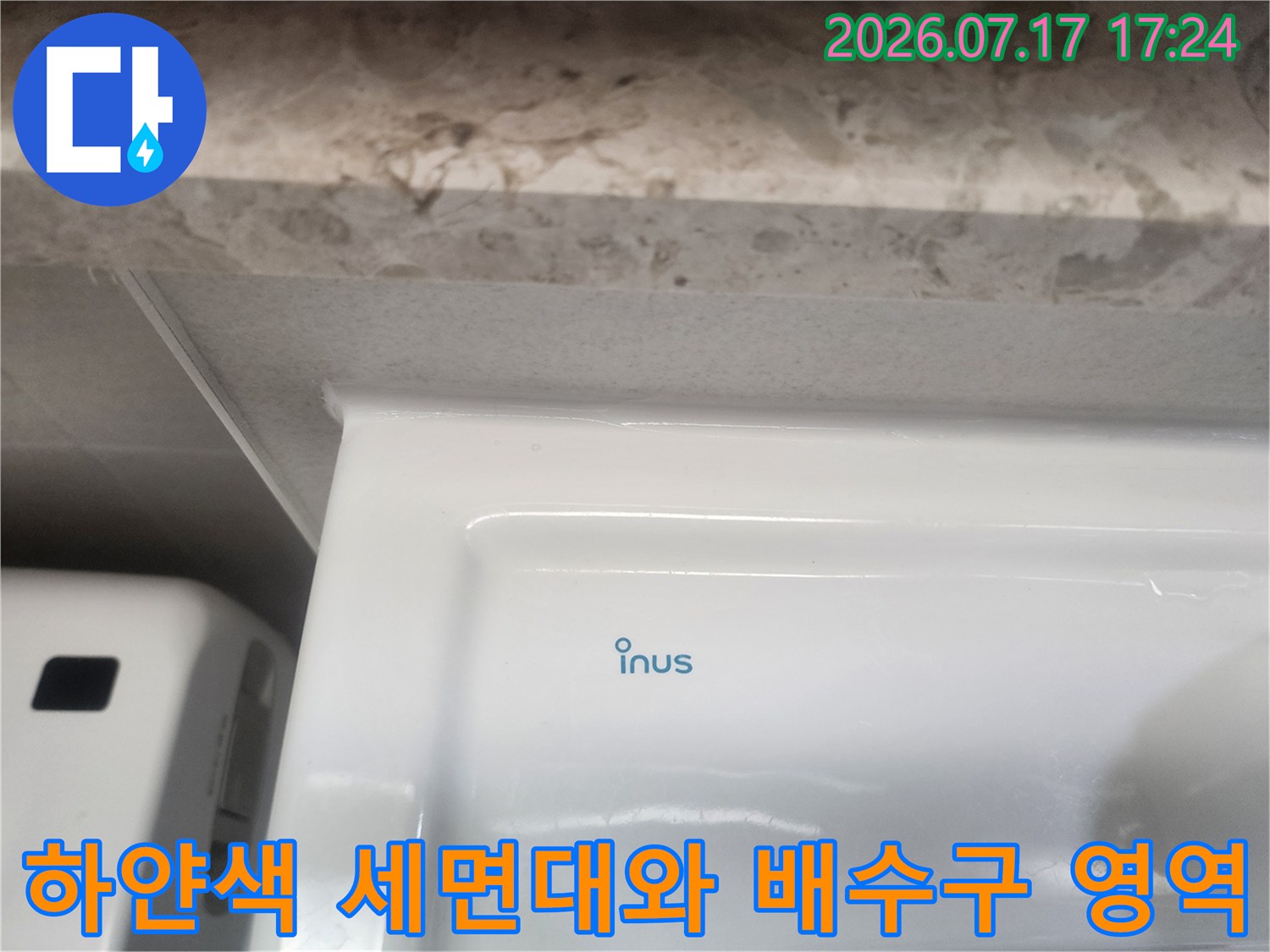 흰색 세면대 하단부의 매끄러운 도기 표면과 주변 마감재