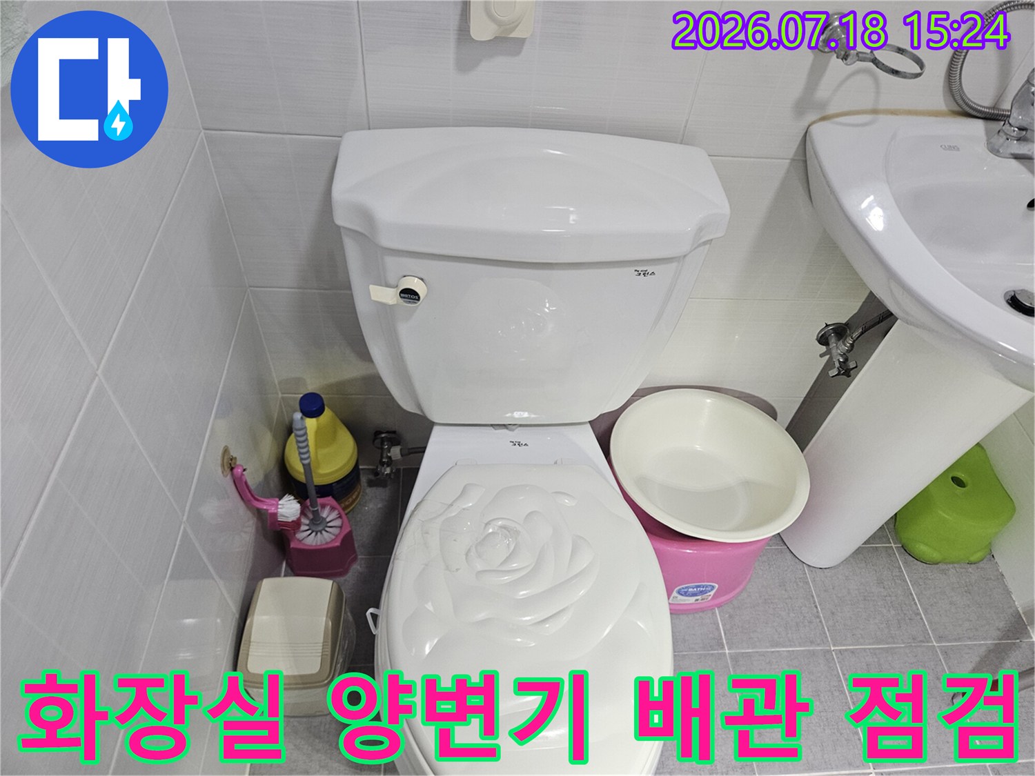 화장실 양변기 주변의 하수 배관과 위생 도구들이 배치된 모습