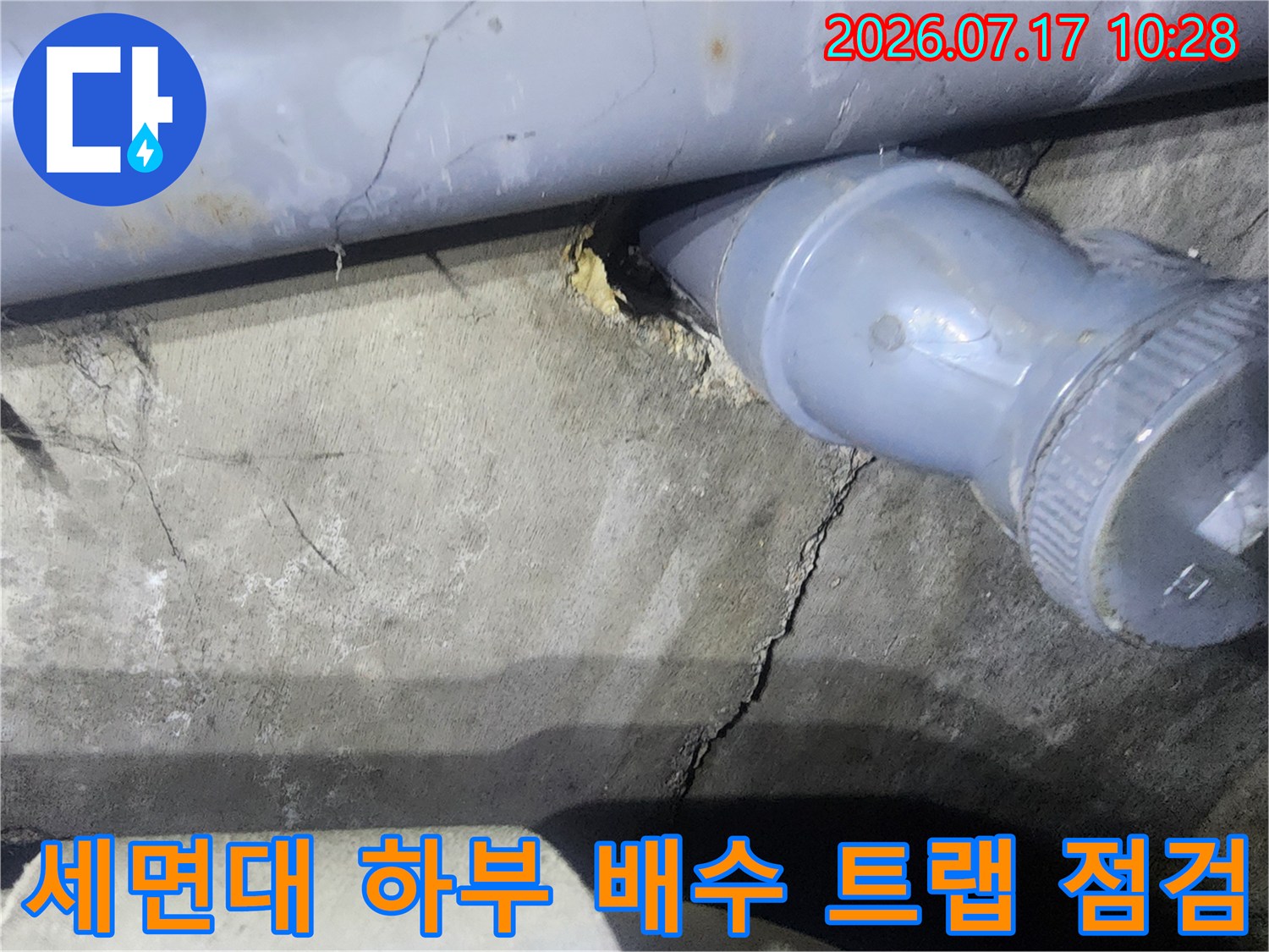 세면대 아래 노출된 배관과 주변의 파손된 마감재 상태