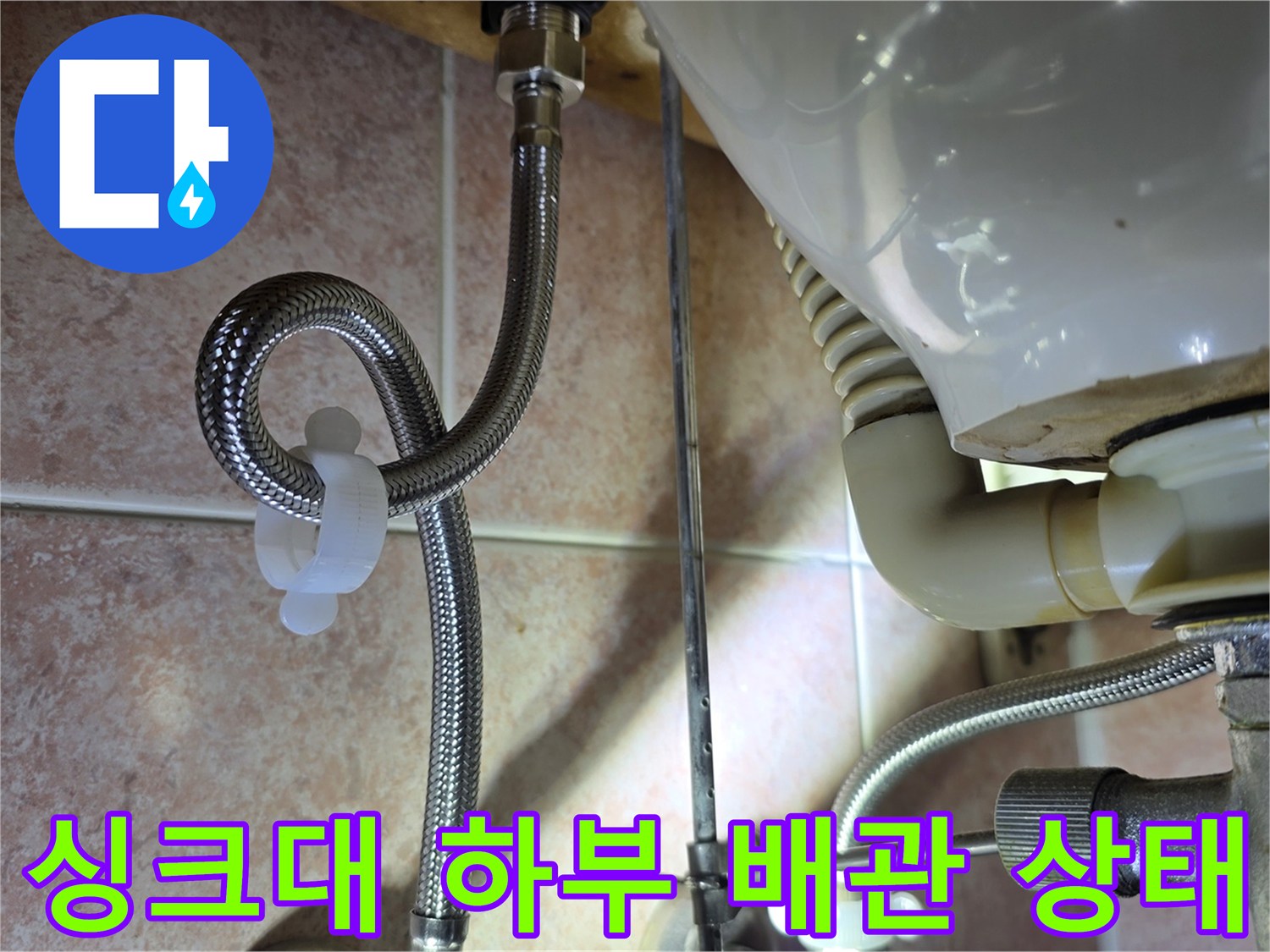 싱크대 아래쪽 은색 주름 호스와 배수관 연결 부위 촬영