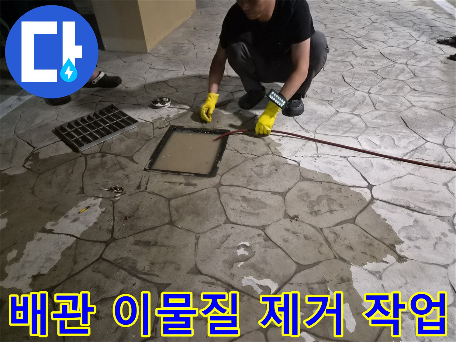 맨홀 내부의 막힌 구간을 뚫기 위해 케이블 장비를 조작하는 작업 장면