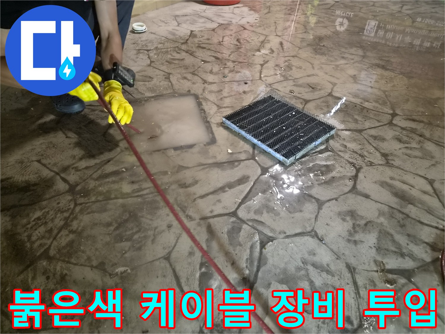 배관 내부 이물질 제거를 위해-붉은색 전동 스프링 장비를 배수구에 투입하는 모습