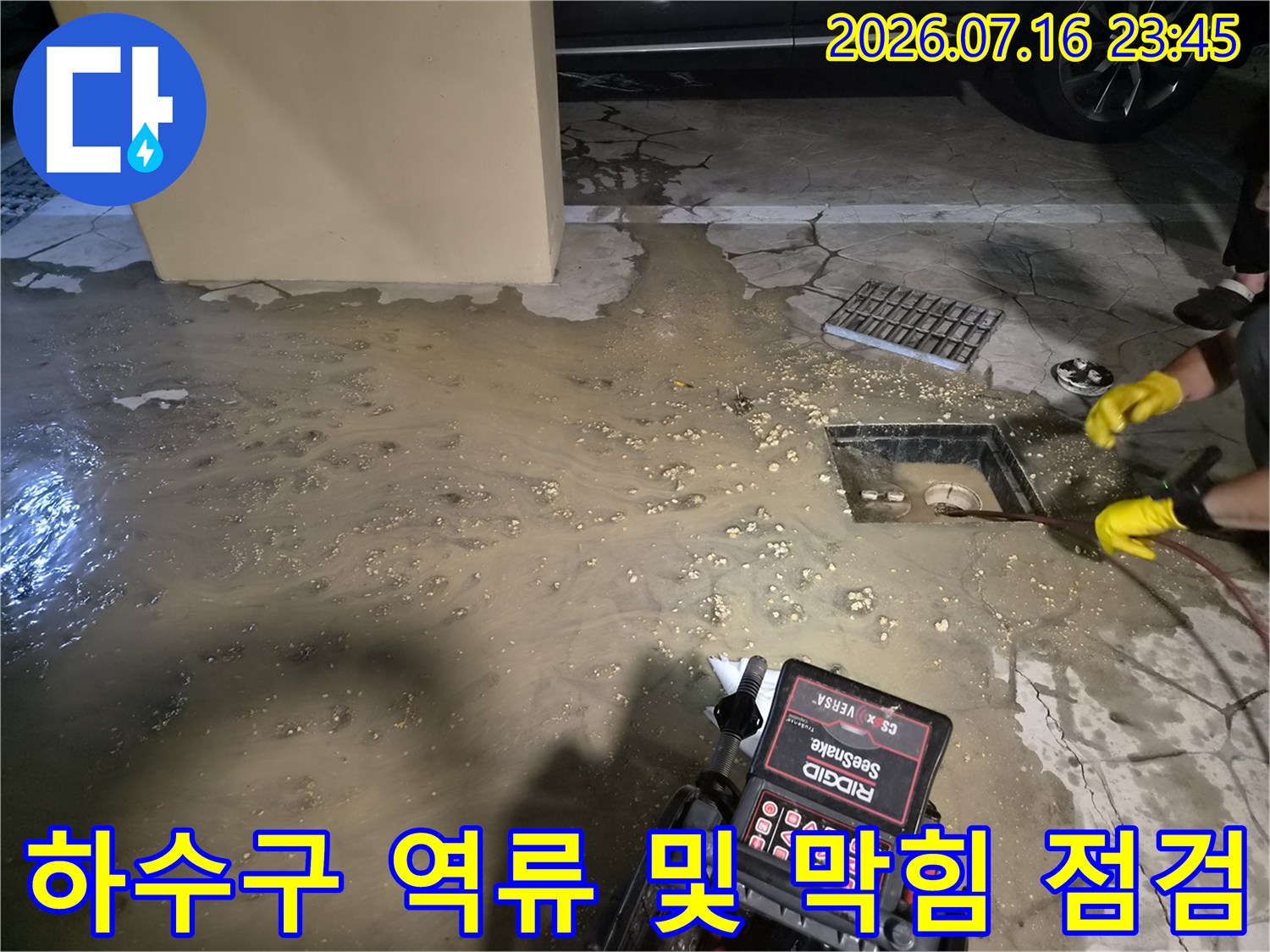 역류한 하수가 고인 배수관 주변을 장비로 청소하는 현장 모습