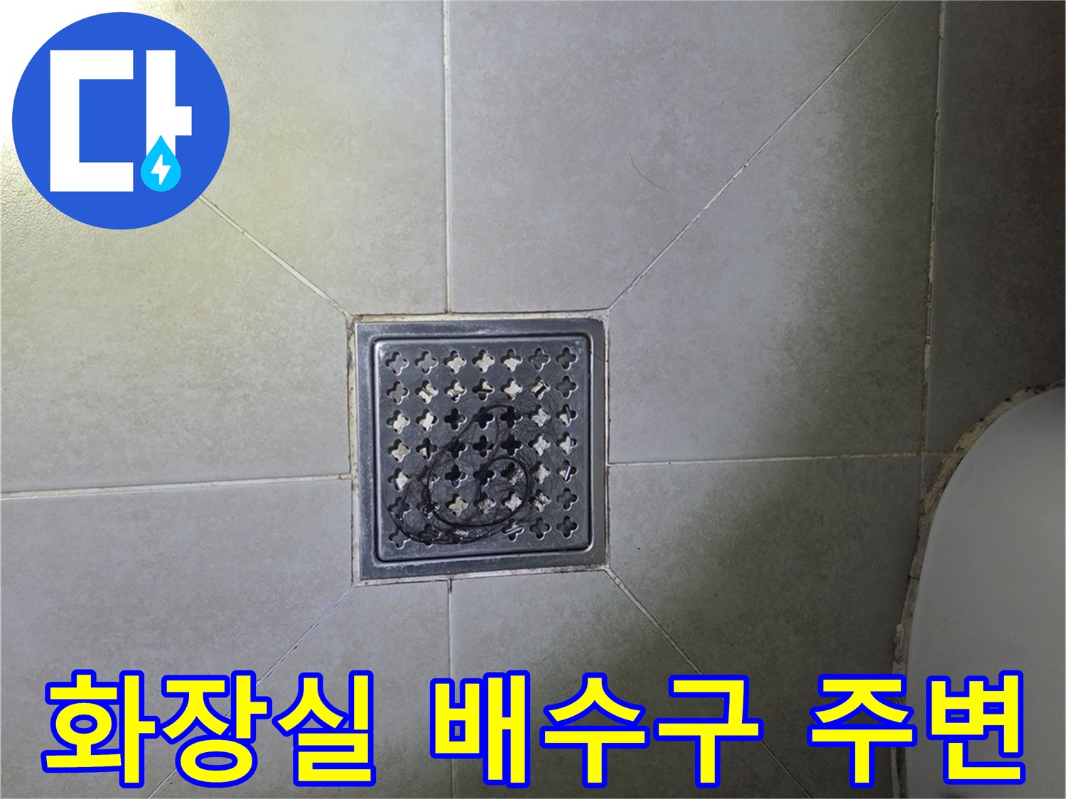 스테인리스 재질의 배수구 덮개와 주변 타일 표면