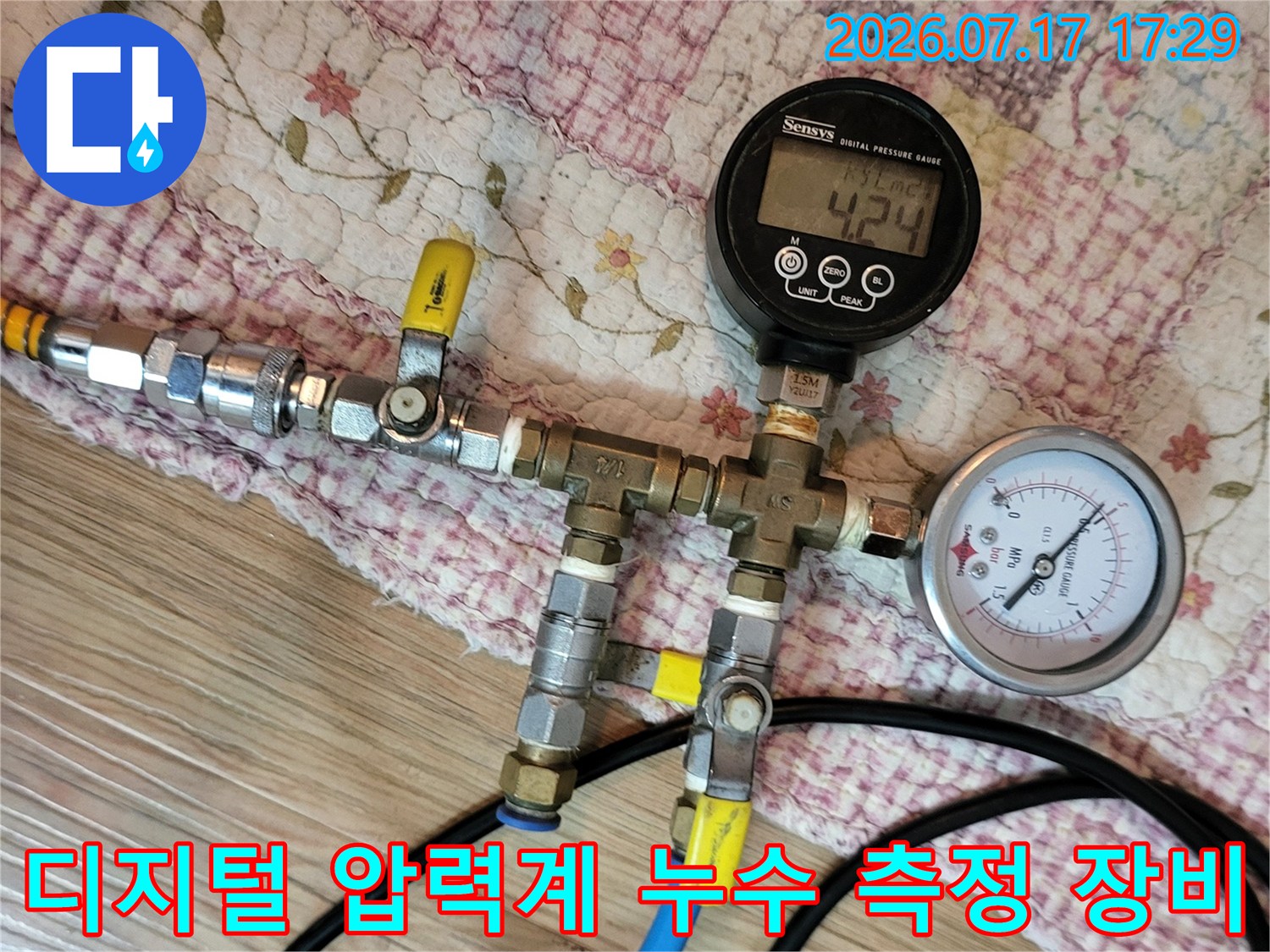 누수 진단을 위해 파란색 호스가 연결된 디지털 압력계와 아날로그 게이지 장비-사진