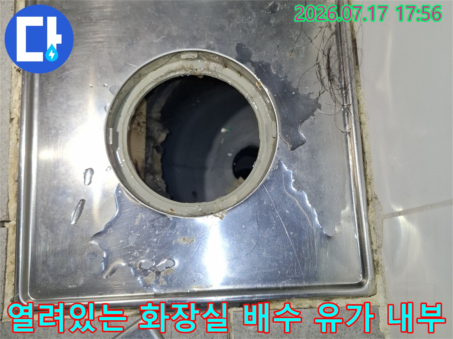 금속-유가 덮개가 열린 상태에서 어두운 하수관 입구가 보이는 사진