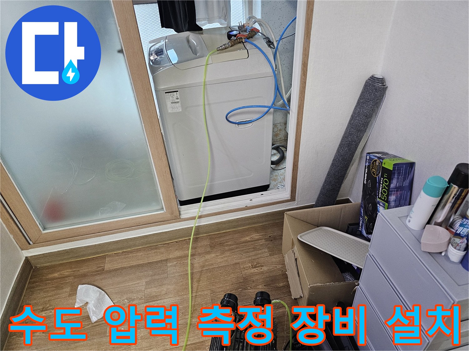 세탁실 내부 배관 연결 부위와 점검용 호스가 배치된 모습