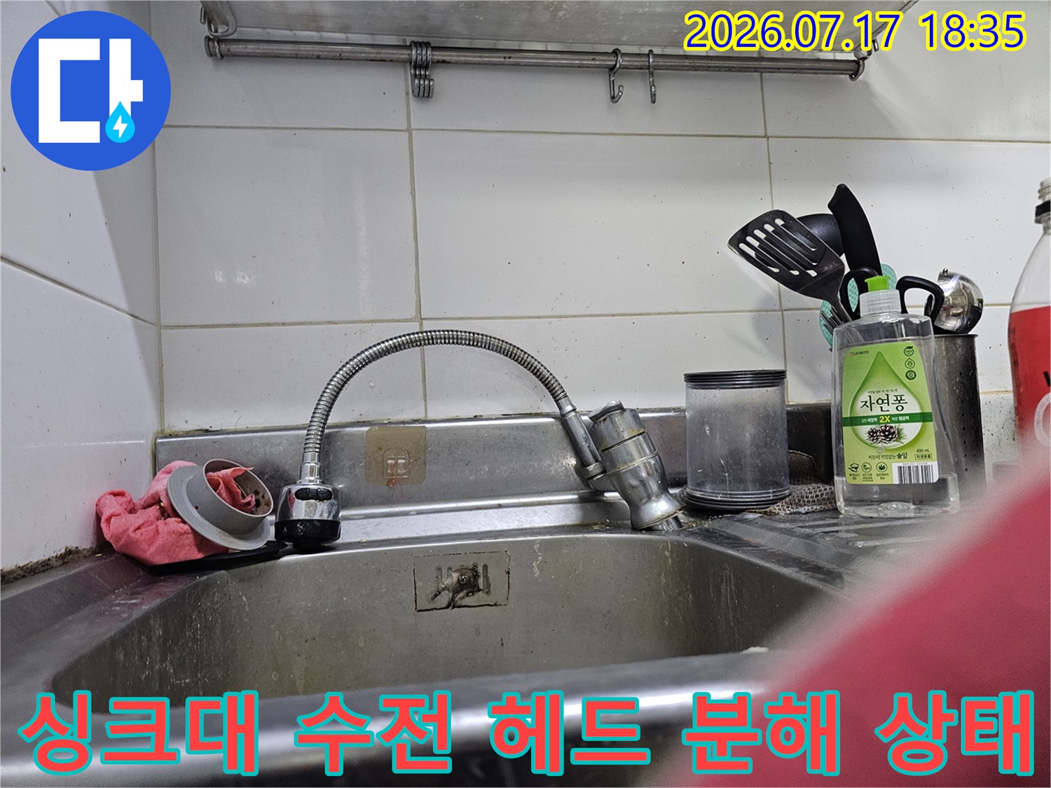 스테인리스 싱크대 볼 위에 놓인 수전 거름망과 분해된 부품들