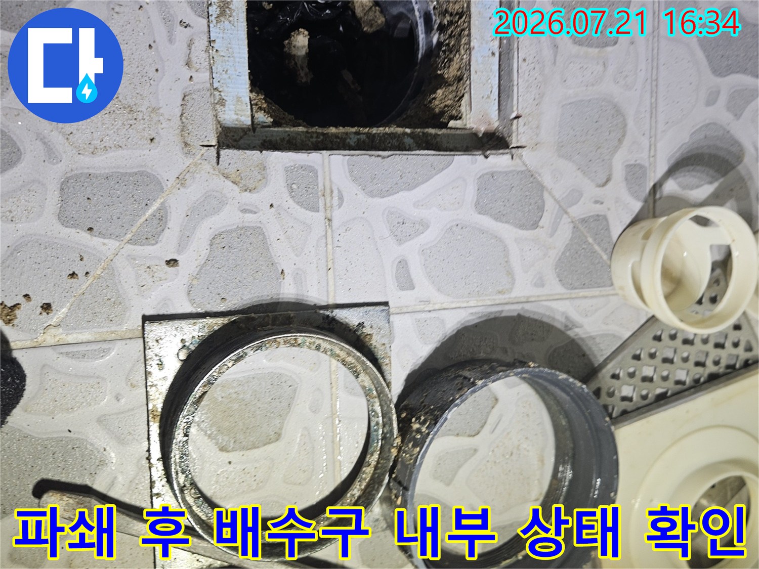 화장실 바닥 파헤친 구간에서 노출된 배관과 주변 오염물 확인