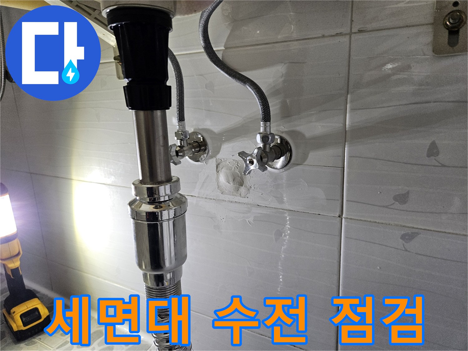 화장실 벽면 앵글밸브와 세면대 호스 연결 상태를 촬영한 사진입니다.