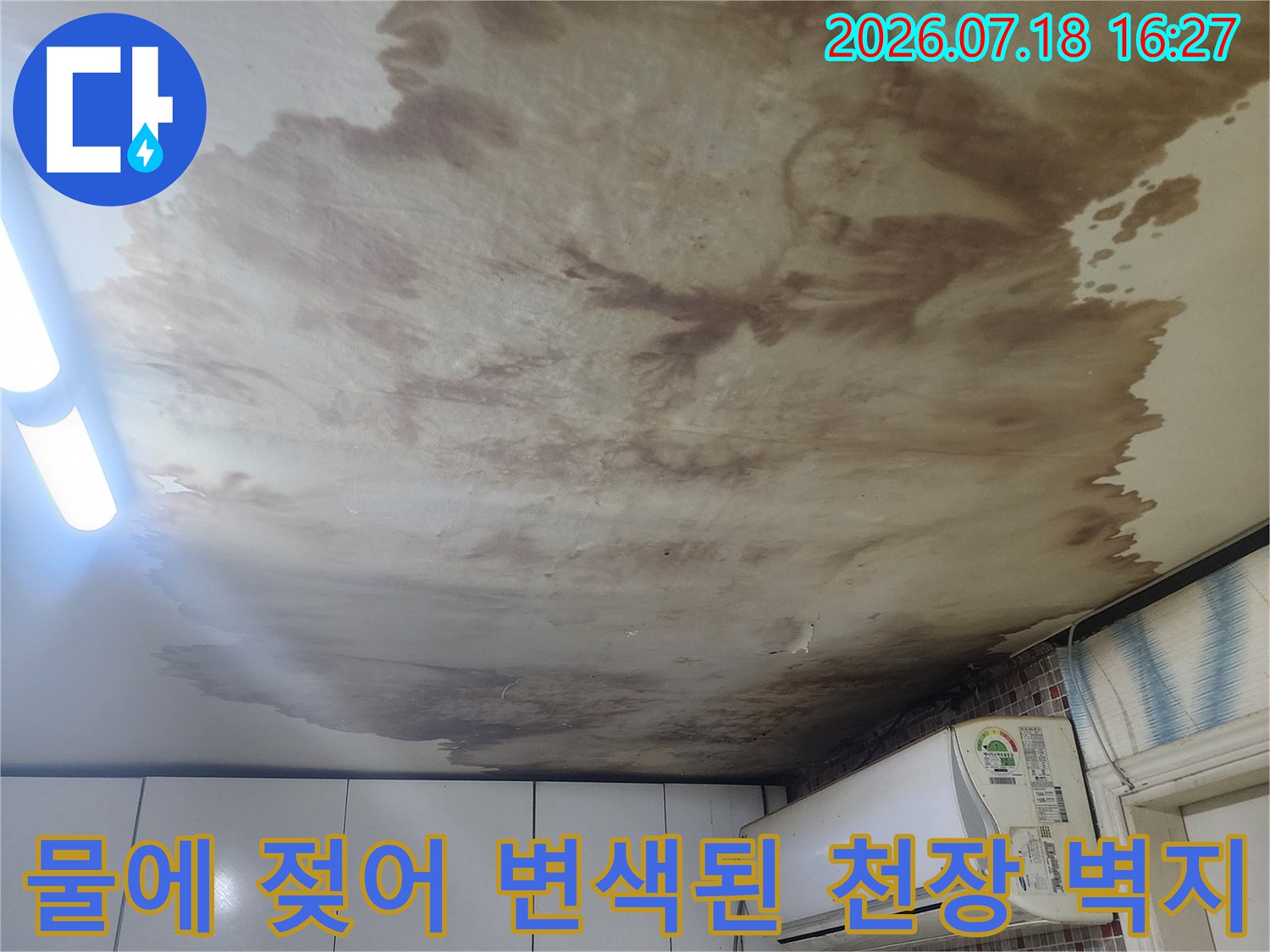 갈색-오염이-심한-천장-벽지와-옆에-설치된-벽걸이-에어컨