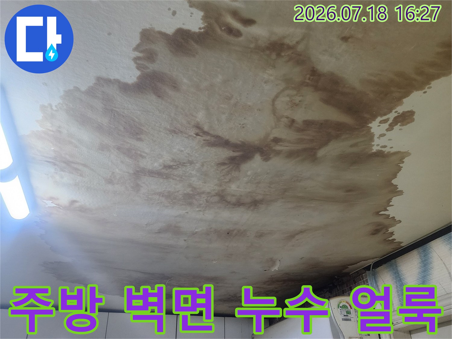 주방 벽지와 에어컨 주변으로 갈색의 심한 누수 얼룩과 곰팡이가 퍼져 있는 모습