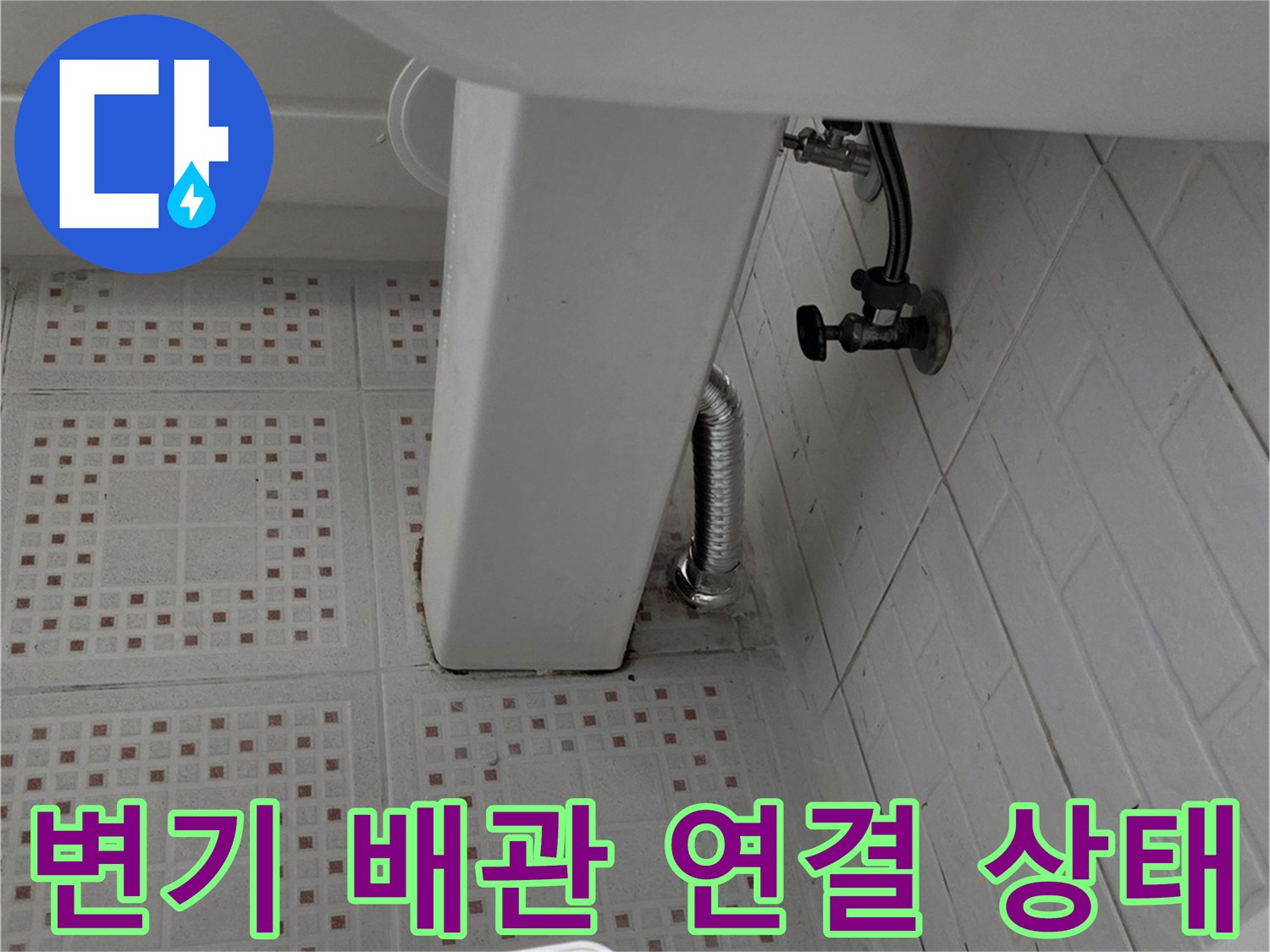 화장실 변기 뒤쪽의 배관 연결 부위와 급수 밸브 모습입니다.