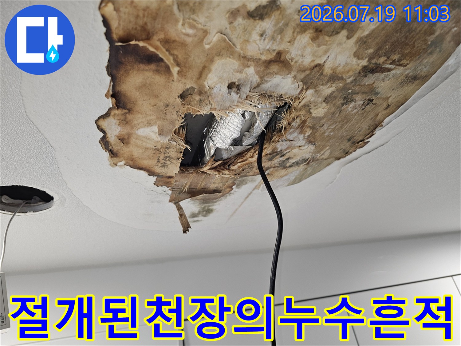 누수로 인해 변색되고 파손된 천장 마감재와 내부 보온재가 보이는 사진