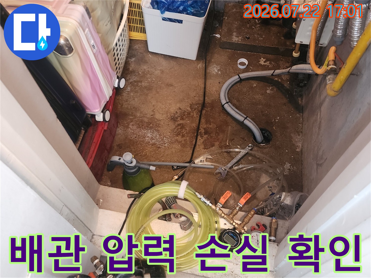 공압 검사기와 긴 호스를 연결하여 배관 계통의 기밀성을 테스트하는 모습