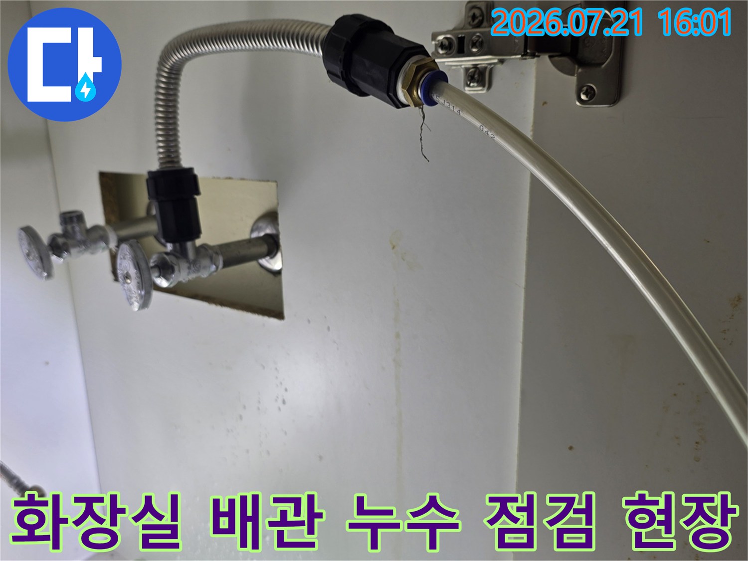 세면대 아래쪽으로 연결된 노출 배관과 굴곡진 금속 배관의 상세 모습