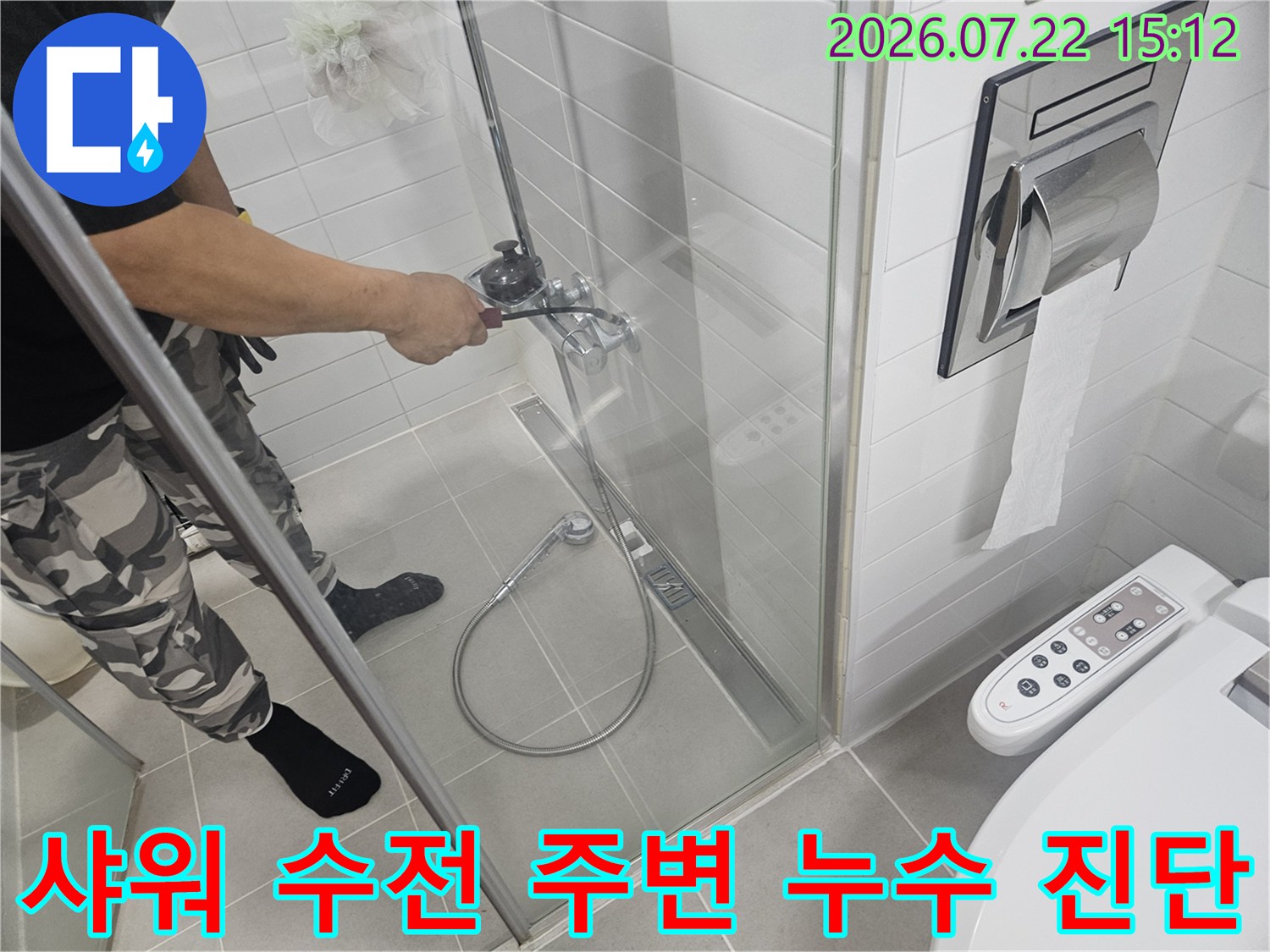 작업자가-화장실-샤워기-수전을-손으로-만지며-누수-징후를-찾고 있는-모습