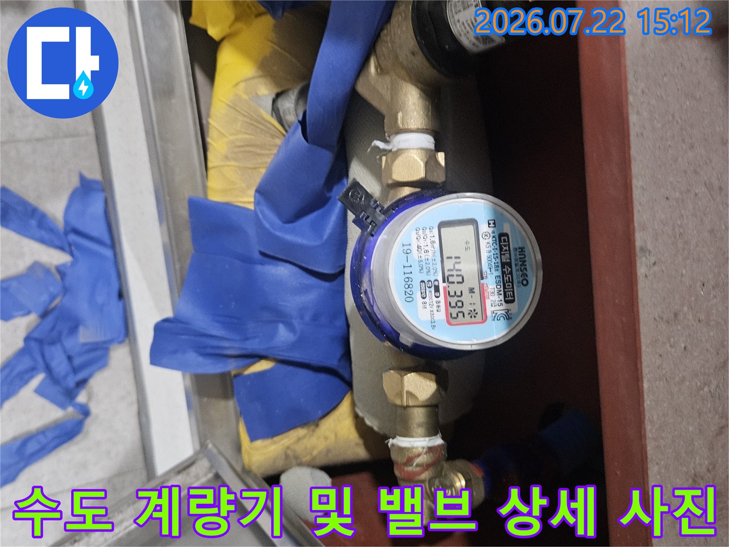 파란색-절연 테이프와-금속제 수도 계량기가-조합된-배관 설비 사진