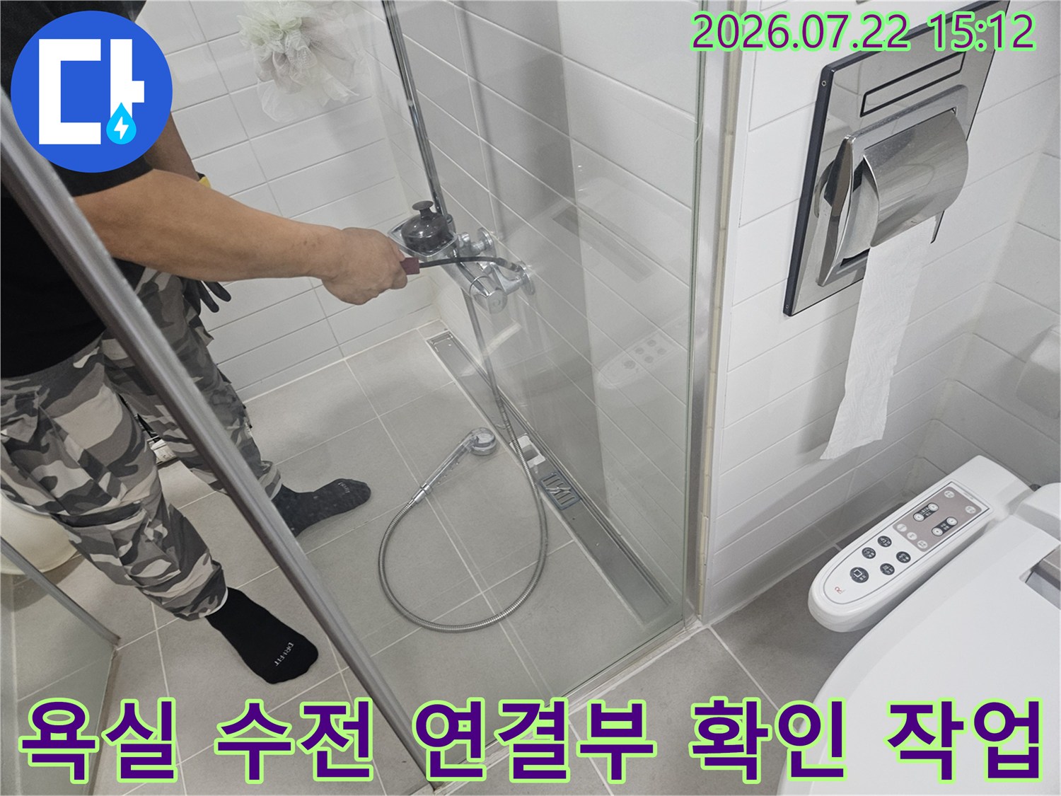 흰색 타일로 마감된 화장실에서 샤워기 수전의 밸브 조작부를 점검하고 있는 현장 사진
