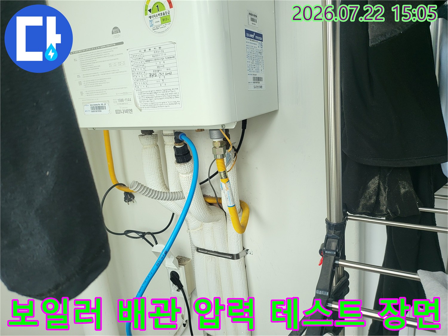 보일러 본체 하단부의 여러 가닥 배관에 파란색 누수 탐지 호스가 연결되어 있는 사진
