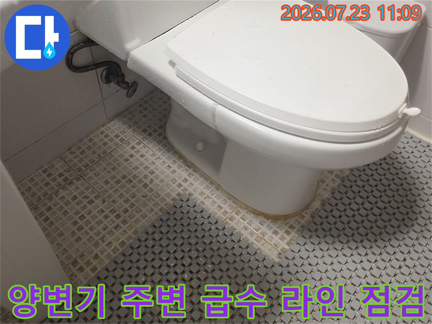 벽면에서 양변기로 연결되는 배관과 흰색 변기가 설치된 화장실 내부의 모습